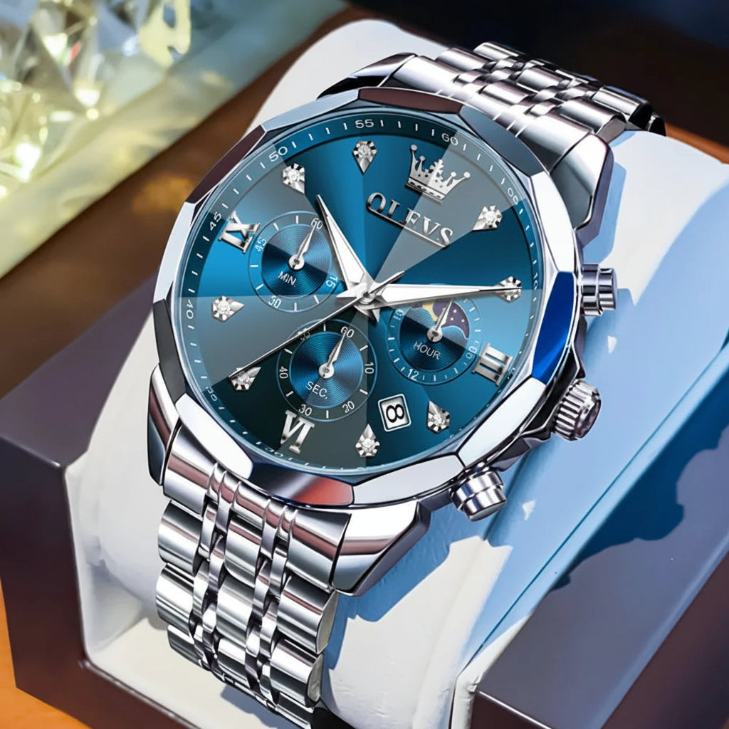 Silver watch with blue face on a white stand, OLEVS brand visible