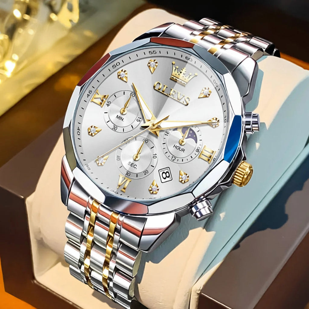 Silver and gold watch with detailed face and OLEVS branding on a brown surface.