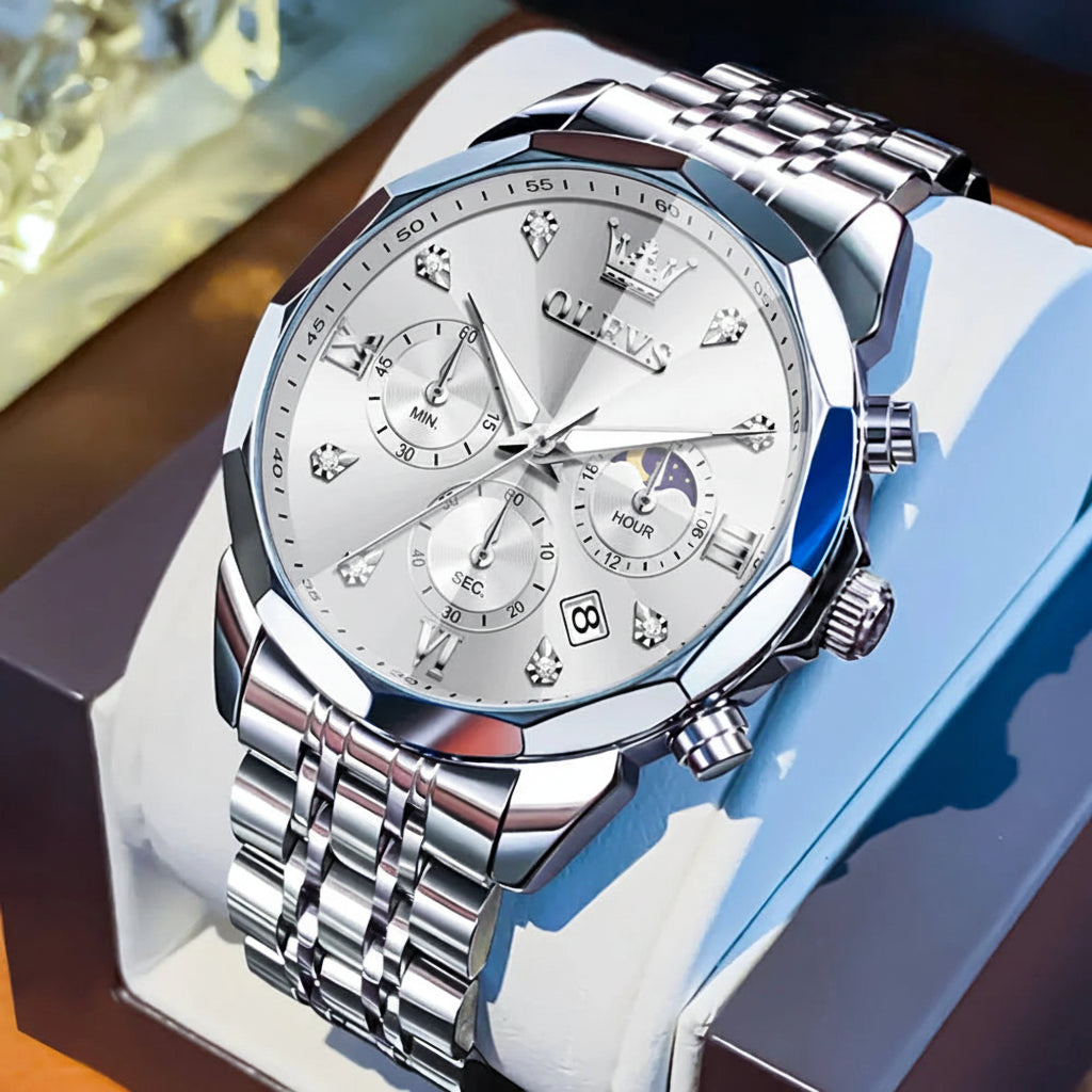 Silver watch with detailed face on a white stand, OLEVS brand visible